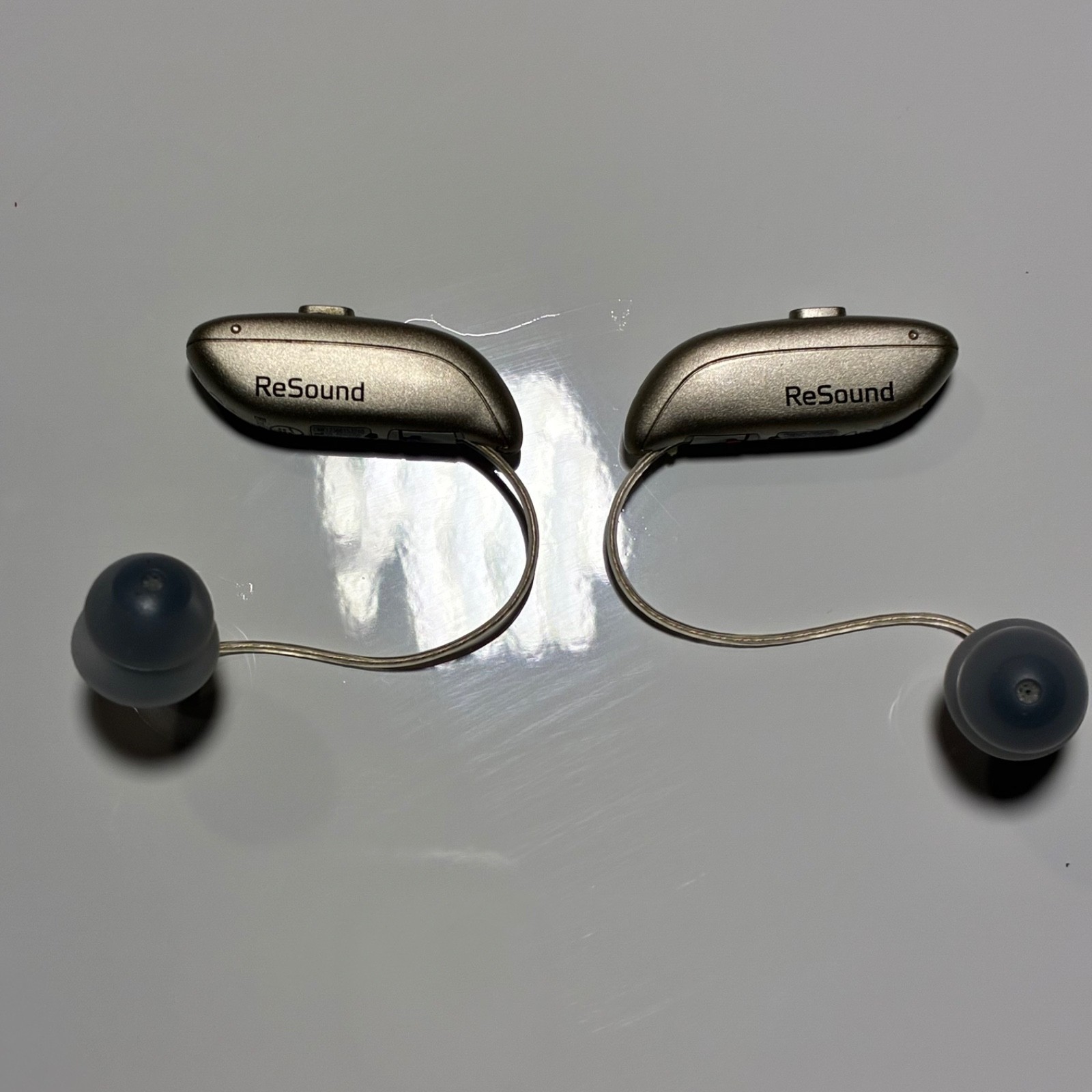 Left and Right Resound GN Hearing Aids and charging station w/cord.