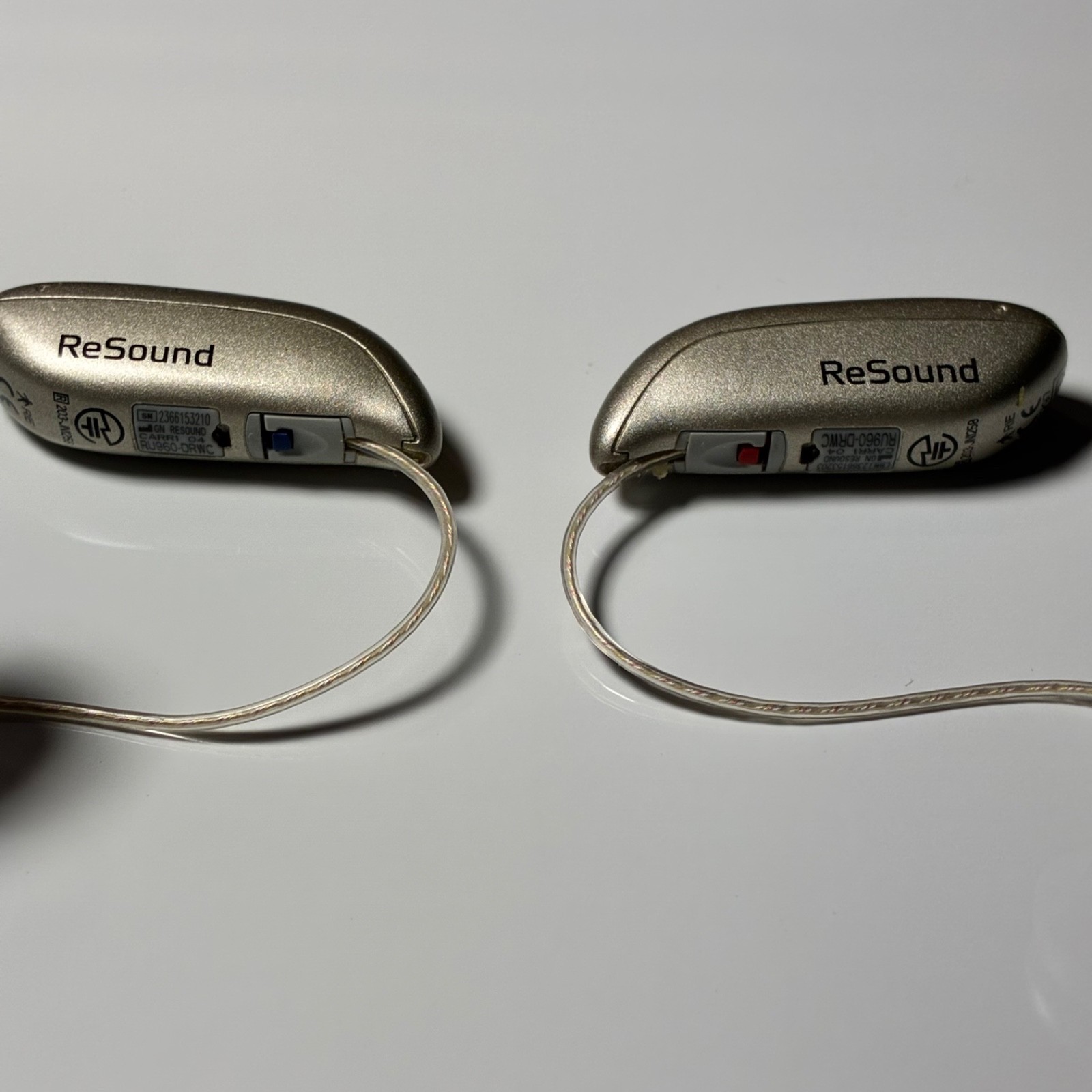 Left and Right Resound GN Hearing Aids and charging station w/cord.